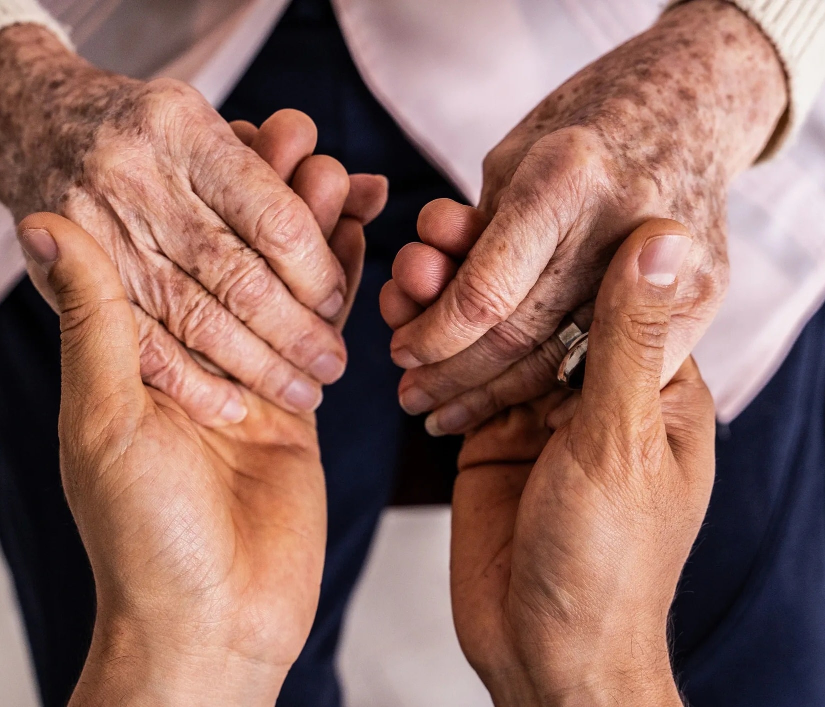 Caregiver holding hands with senior in memory care